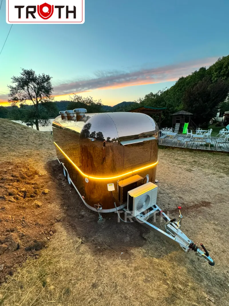 Rose gold food trailer with LED accent lighting at sunset